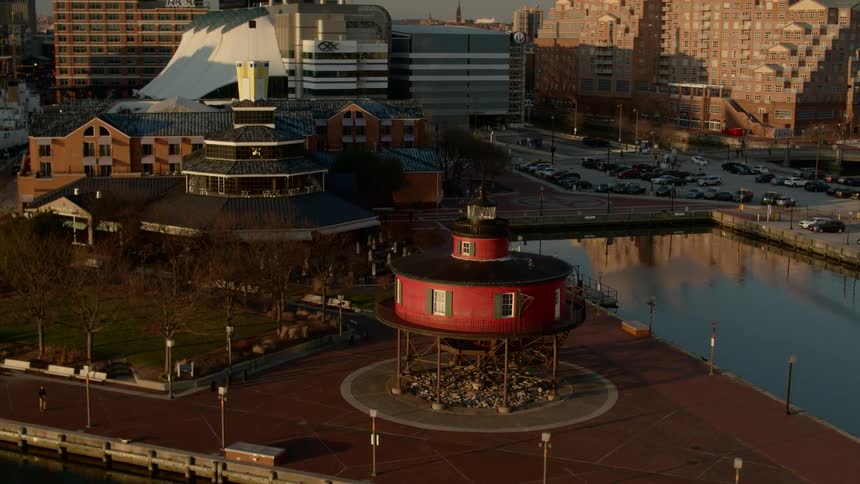 A circular structure and a pool sit in a city park