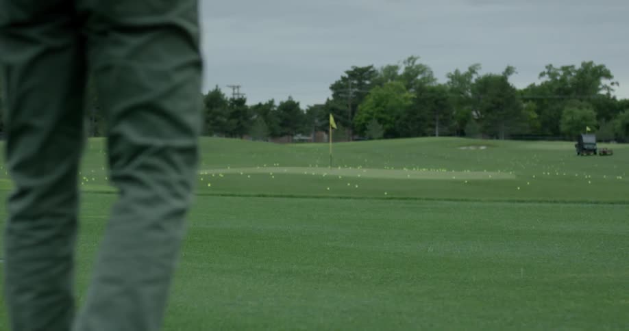 A golfer hits a ball on the green
