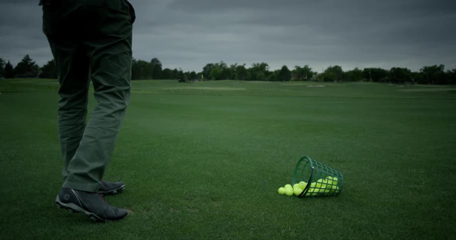 A man is driving golf balls on a course
