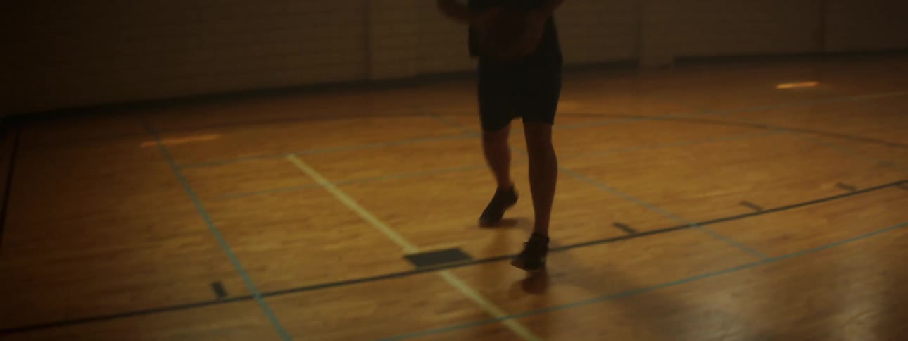 A man shoots baskets in a gym