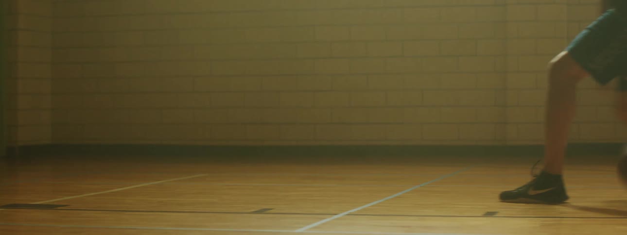 Person plays dribbles basketball on court