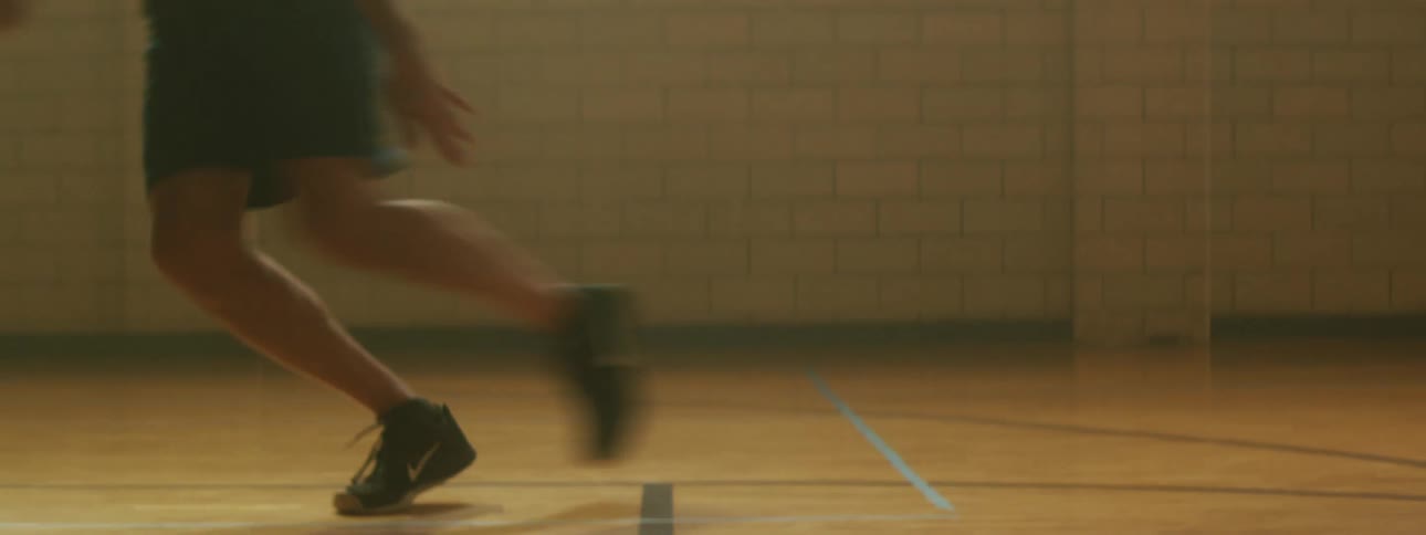 Man runs on the gym floor then touches the floor and runs back