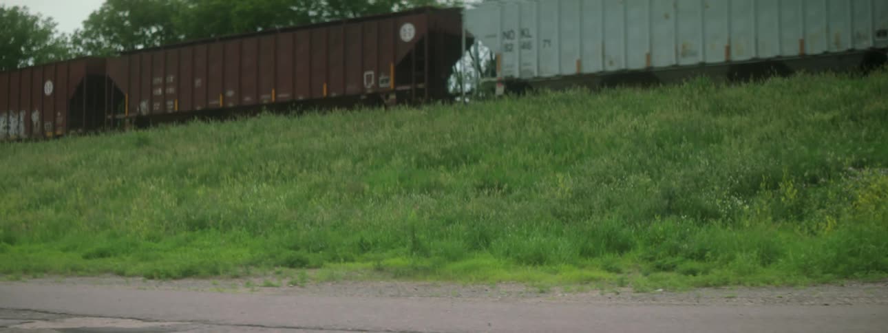 A person running with train carts moving in the background