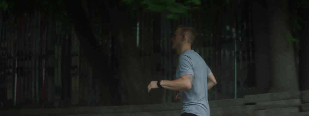 A man is running down the neighborhood sidewalk
