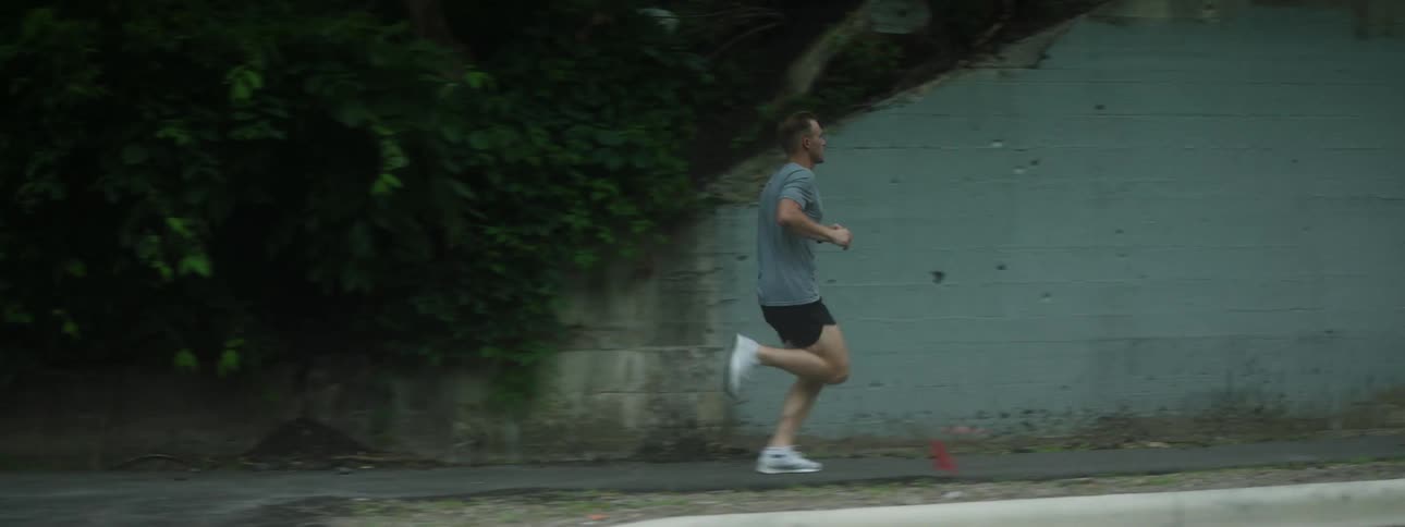 Man wearing shorts and running shoes jogging on city streets