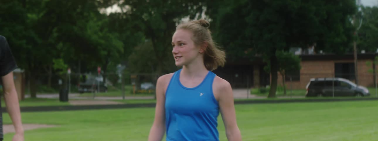 Teenagers in sportswear walking together talking on athletic field
