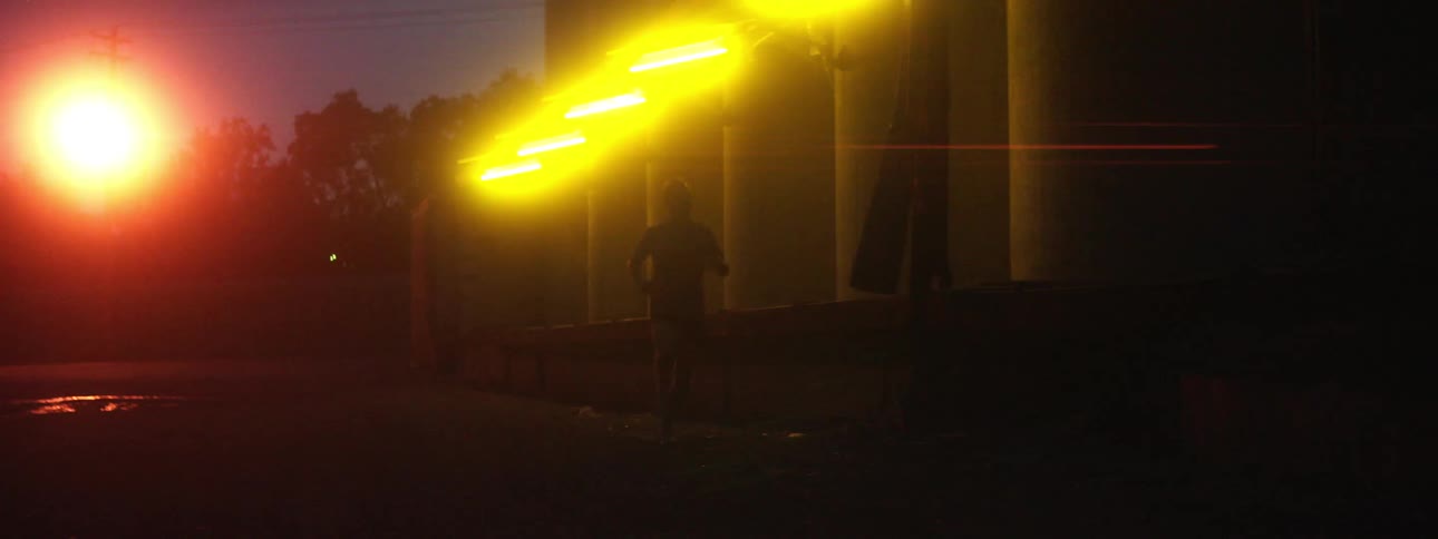 A jogger runs past a building lit up with yellow lighting