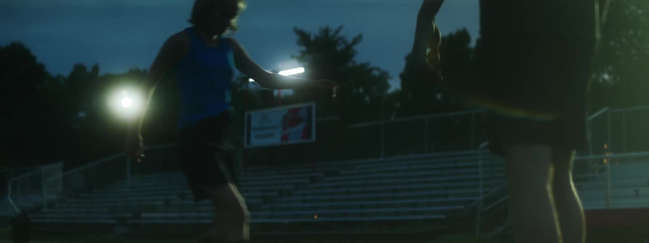 A boy and girl kick a ball back and forth
