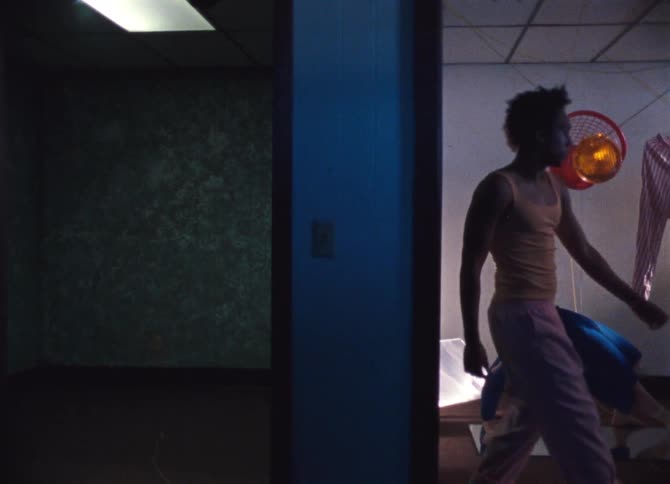 A teenager slowly dances as he moves through a room with a female doing a back bend