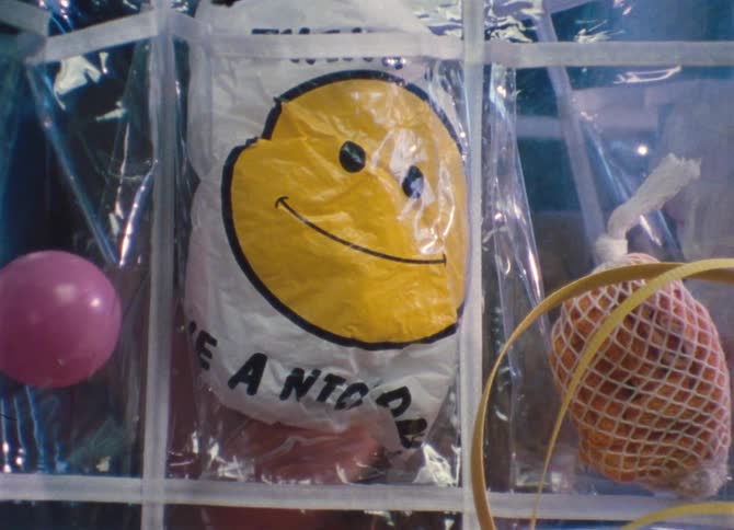 A happy face bag stuck in a plastic clear bag