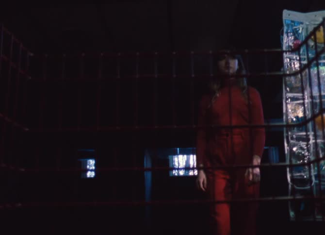 A teenager walks around a display in a dark room