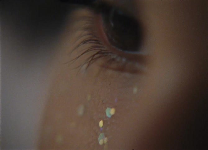 A Black female closes her eye and then opens it