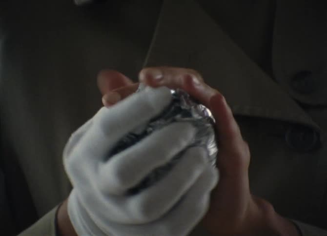 A person crumpling up a piece of foil