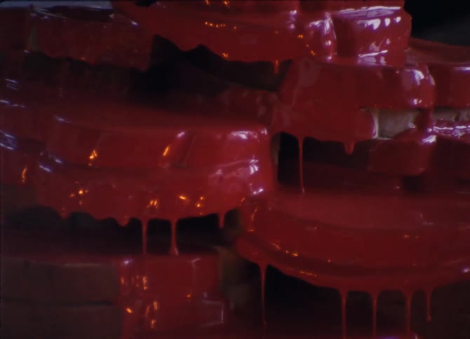 White bread sandwiches stacked on a plate with red blood like icing dripping down