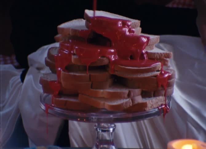 A teenager pours ketchup over a pile of bread
