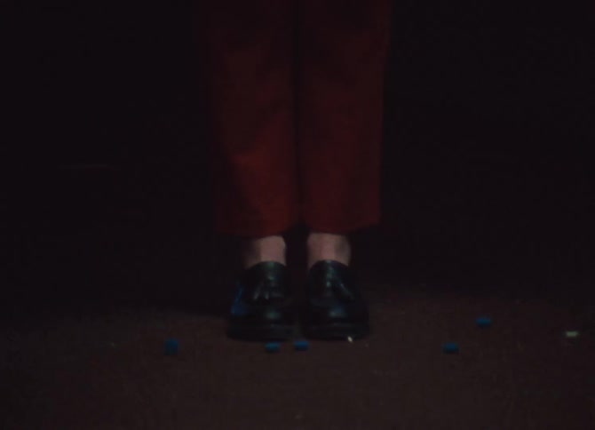 A white woman drops blue objects out of a large plastic bag with pouches