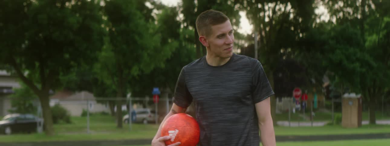 The teen walks with a ball