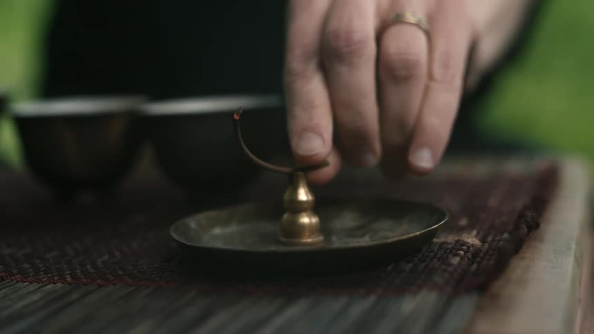 Person places burning incense on incense burner