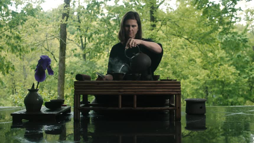 Woman performing japanese tea ceremony near a forest