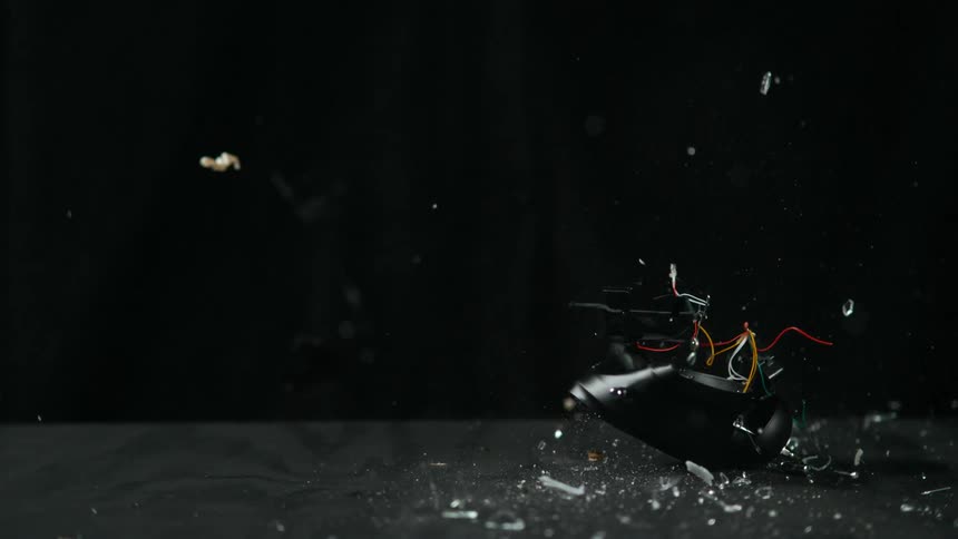Shattered alarm clock falls to floor in slow motion