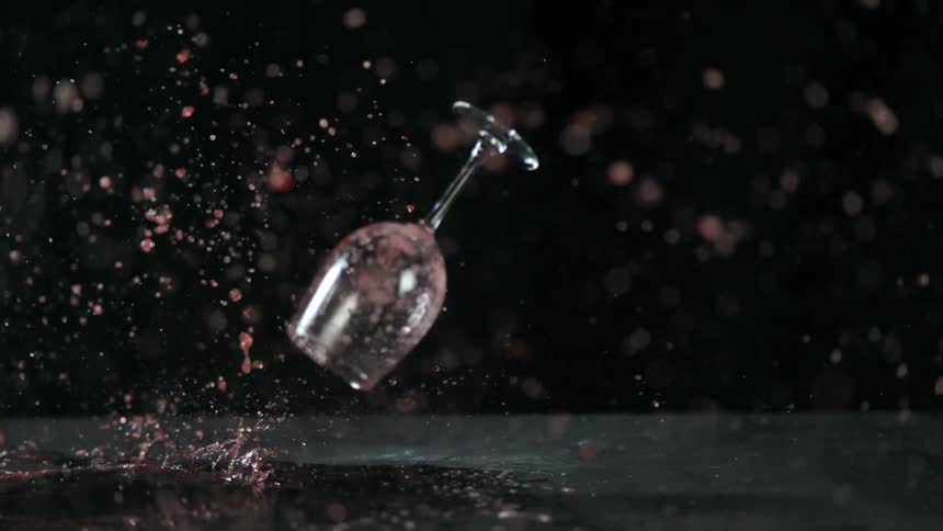 Wine glass drops to floor and splashes wine