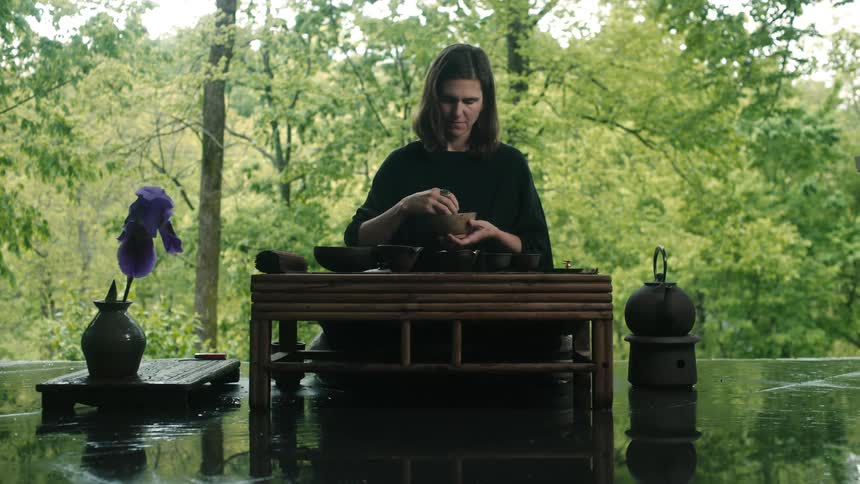 Woman at small wooden altar sorting objects into small stone bowls