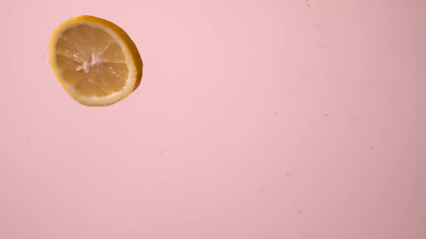 Lemon slice in front of pink background