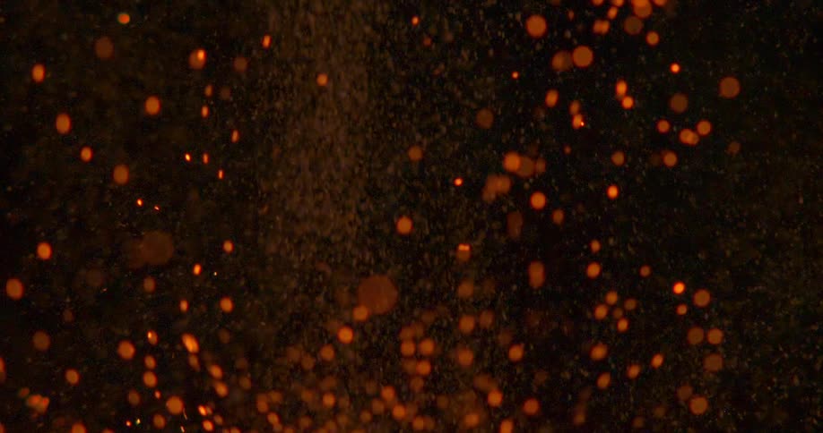 Orange sparks and smoke against black background