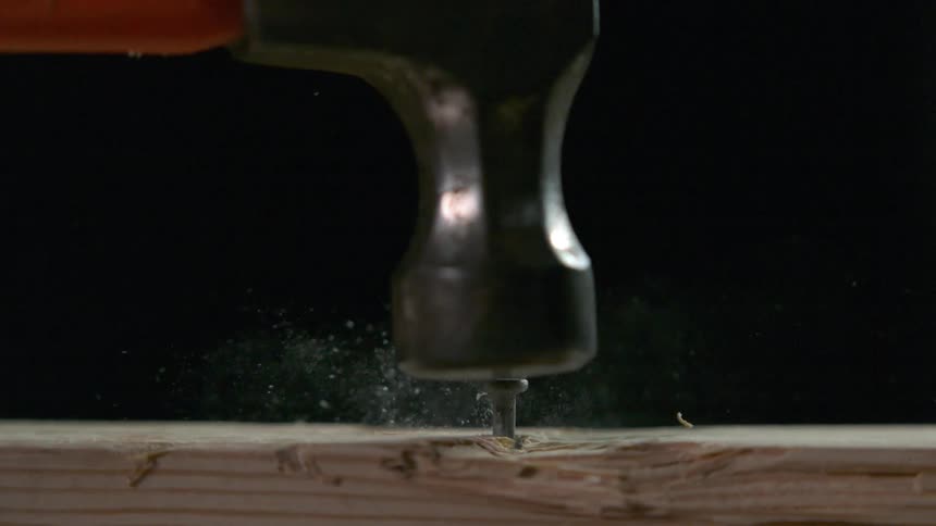 Hammer hitting a nail on the head in slow motion