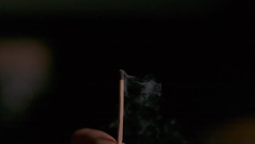 A person blows out a single match