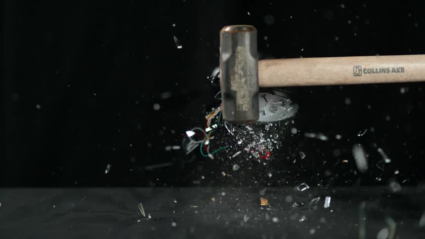 Hammer shatters clock spraying fragments into air