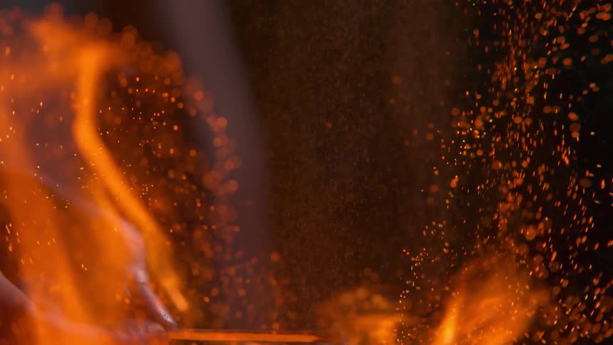 A man holds a match and catches something on fire