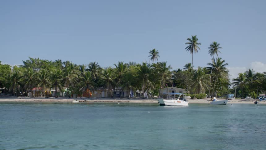 The boats sit in the water near the beach
