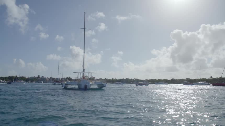 Boats on lake under blue sky with clouds