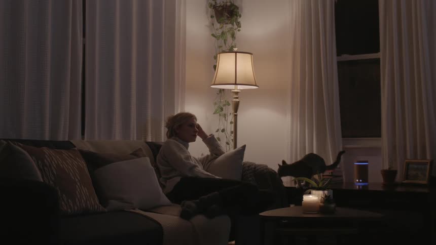 A white woman and her cat hang out in a living room