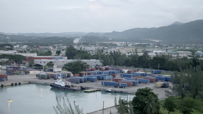 Shipping containers parked in a lot near the water and a short dock