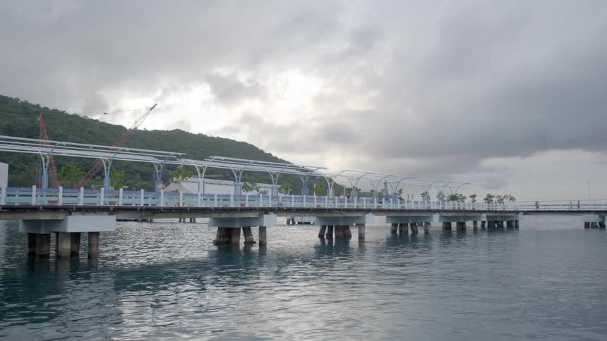 A man runs across a large bridge on a body of water
