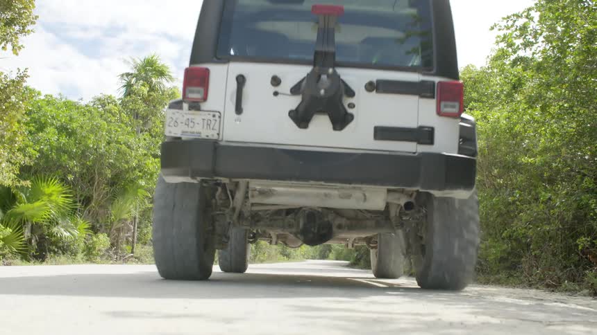 A jeep drives down a road