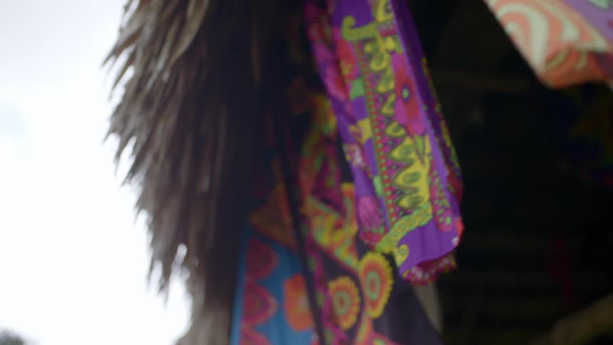 Colorful patterned flags fly from the ceiling of a hut