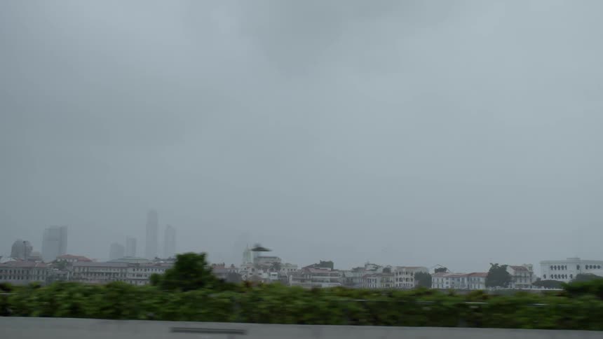 A taxi drives along a highway where a neighborhood and downtown are across in the distance