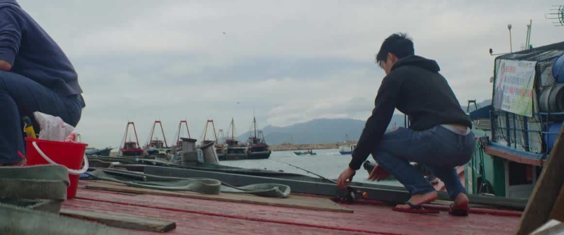 A person near the coast putting down a fishing rod