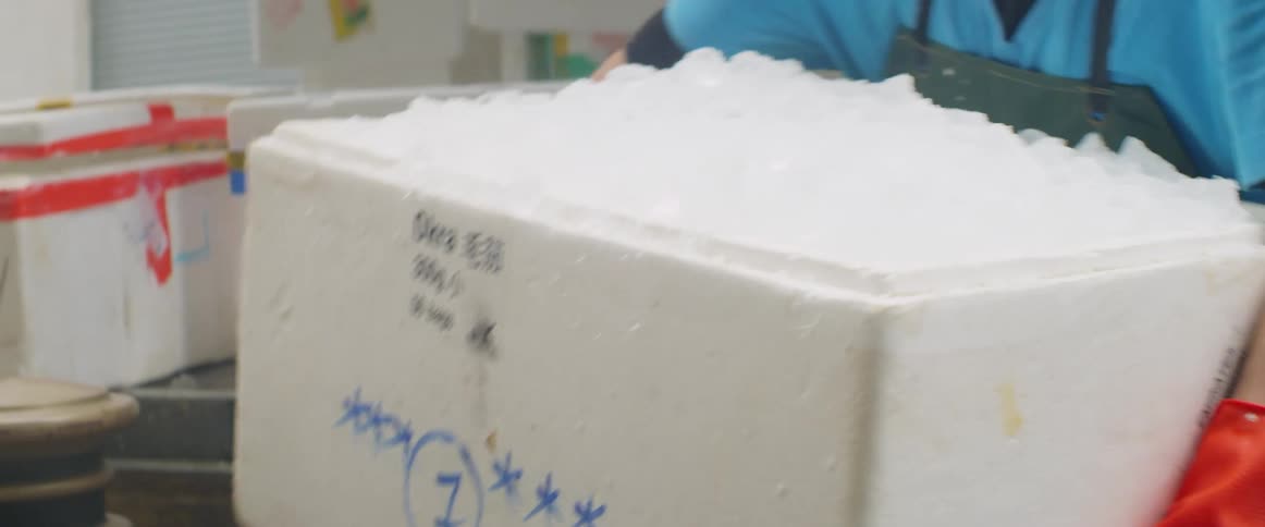 Two men unload ice from a shipping truck