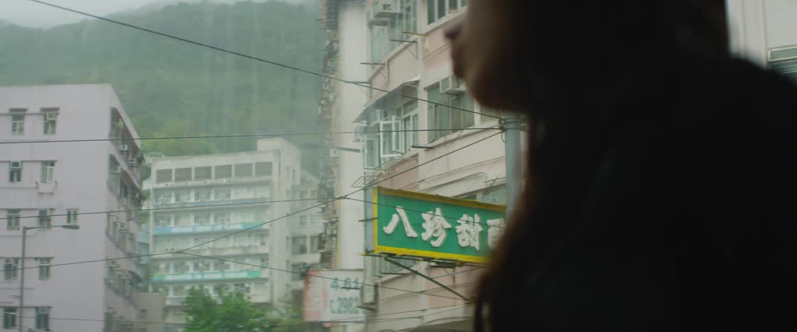 A woman standing on a street with buildings in the background