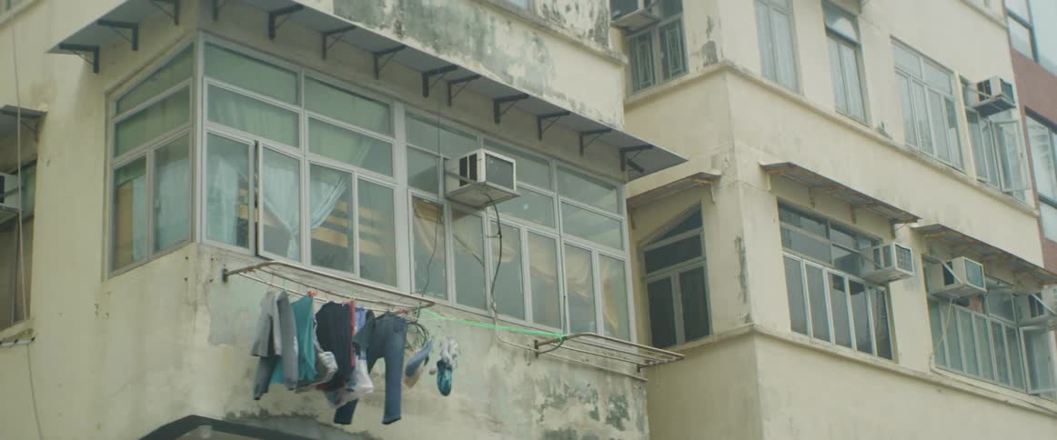 Clothes hang to dry on a clothesline outside an apartment building