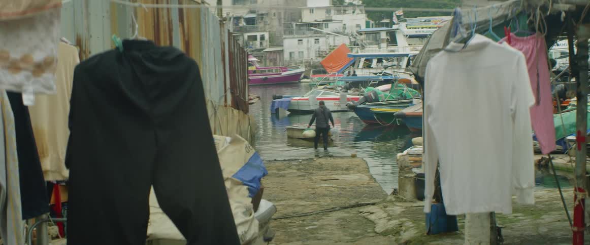 A person fills large water bottles in a river after walking into it