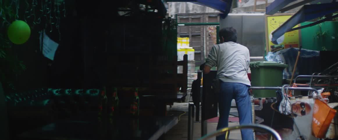 A man pushes a car in an alley