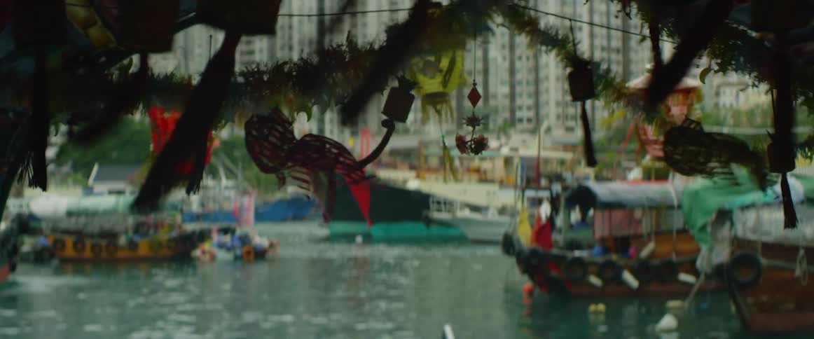 Boats float in the water as decorative lanterns hang nearby
