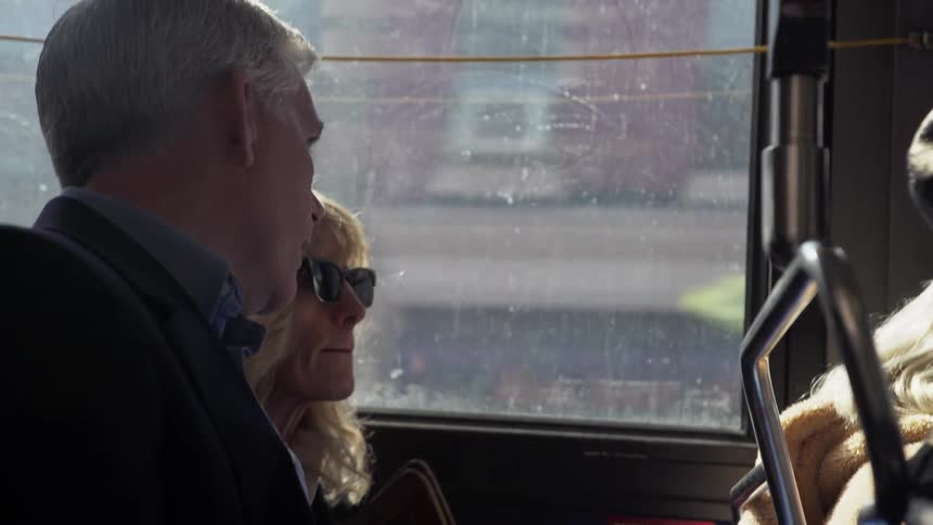 A man and woman sitting on a bus