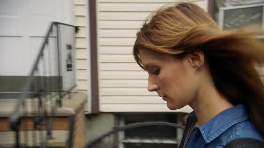 A woman walks past the homes in the neighborhood