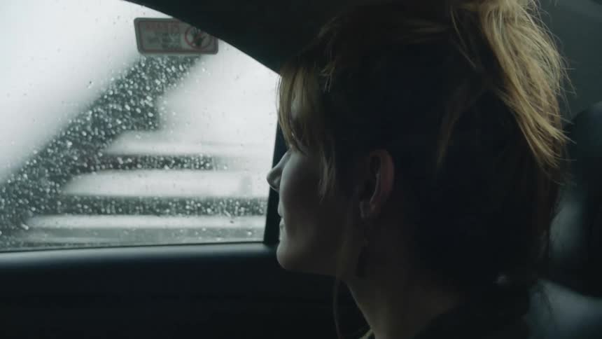 A woman sits in a car and chats with the driver